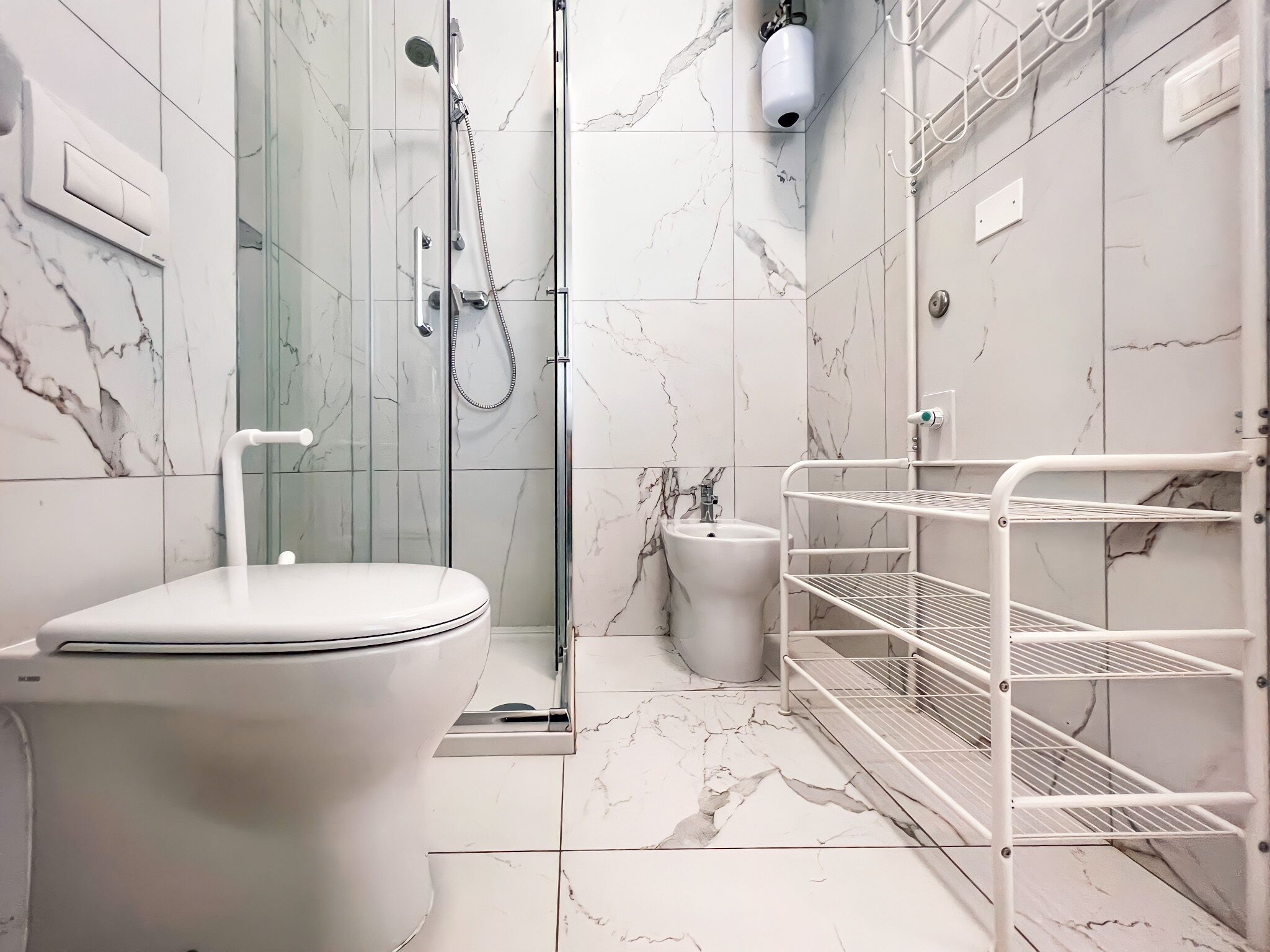 Un bagno moderno con WC, bidet e cabina doccia in vetro.