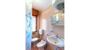 Une salle de bain équipée de toilettes, d’un bidet et d’un lavabo.