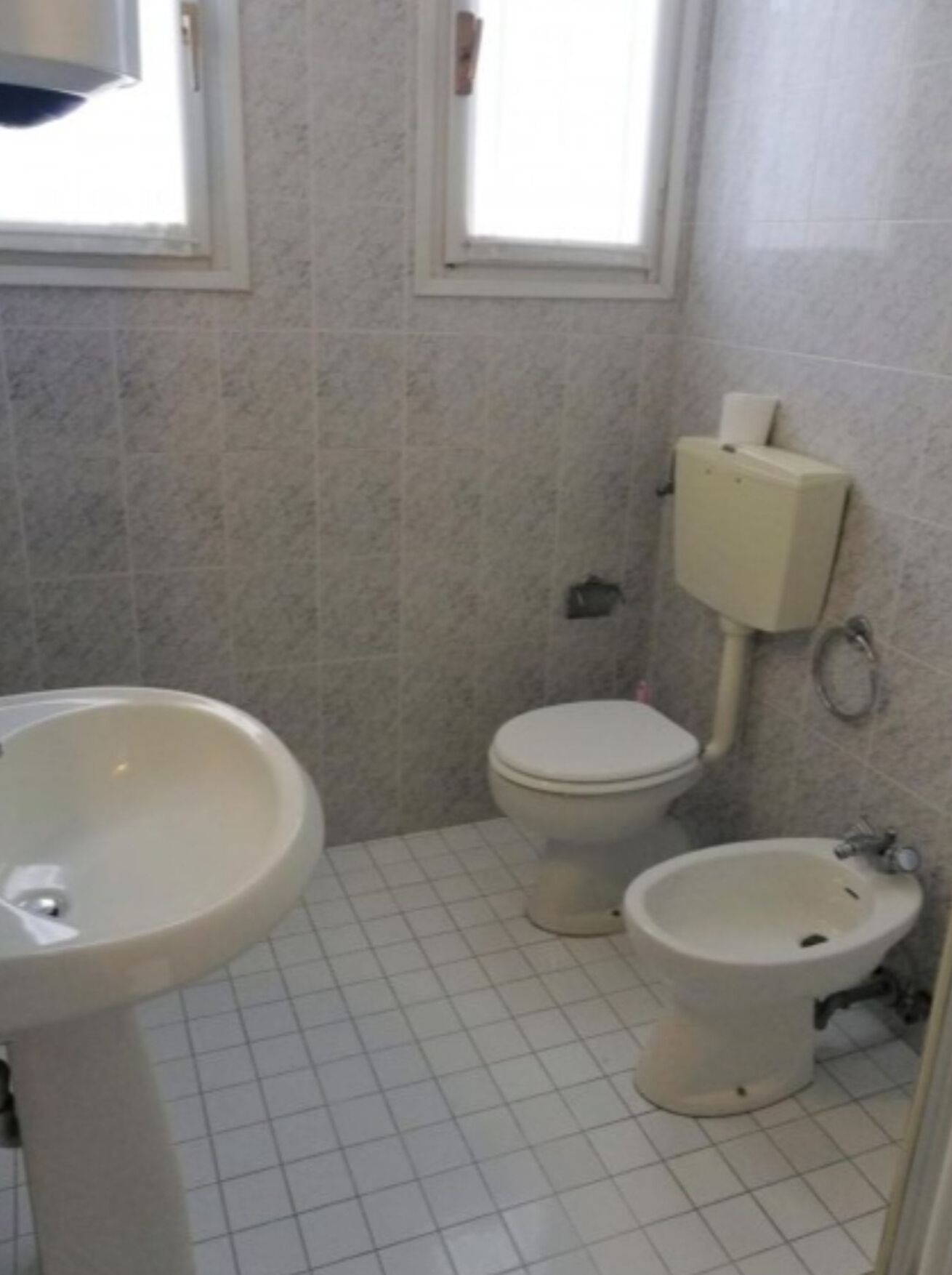 Un baño pequeño con inodoro, bidé y lavamanos.
