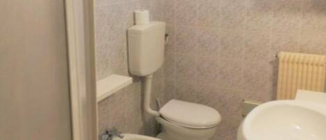 A small bathroom with a toilet, bidet, and sink.