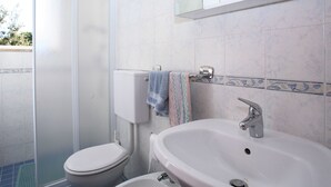 Ein Badezimmer mit Toilette, Waschbecken und Dusche.