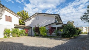Ein Wohnhaus mit gepflasterter Auffahrt, einer Veranda und einer Garage.
