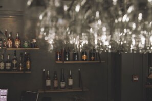 A bar area with shelves of various liquor bottles and glasses. - Home Hotel Carlshamn (Karlshamn)