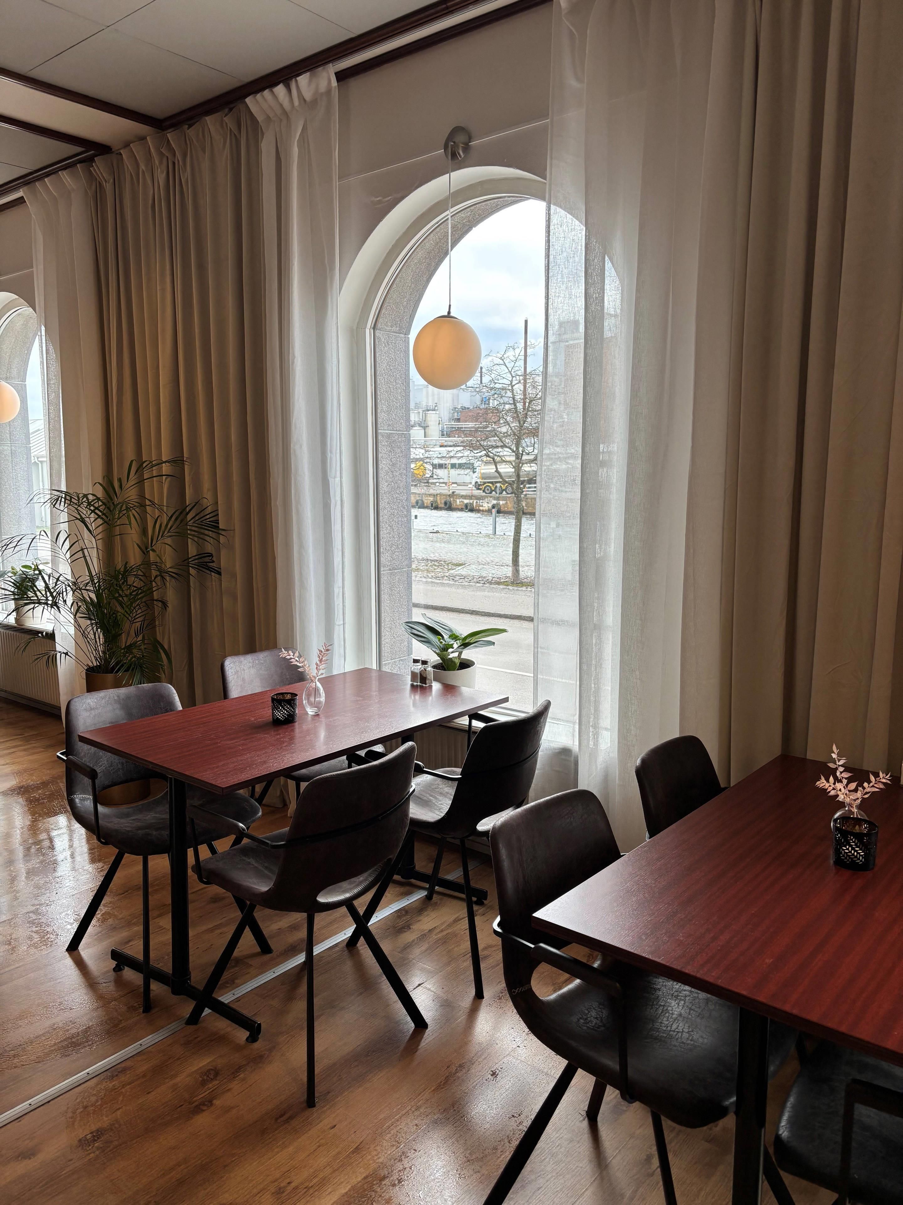 Una sala de conferencias con una mesa de madera, sillas negras y vistas amplias a través de ventanas grandes.