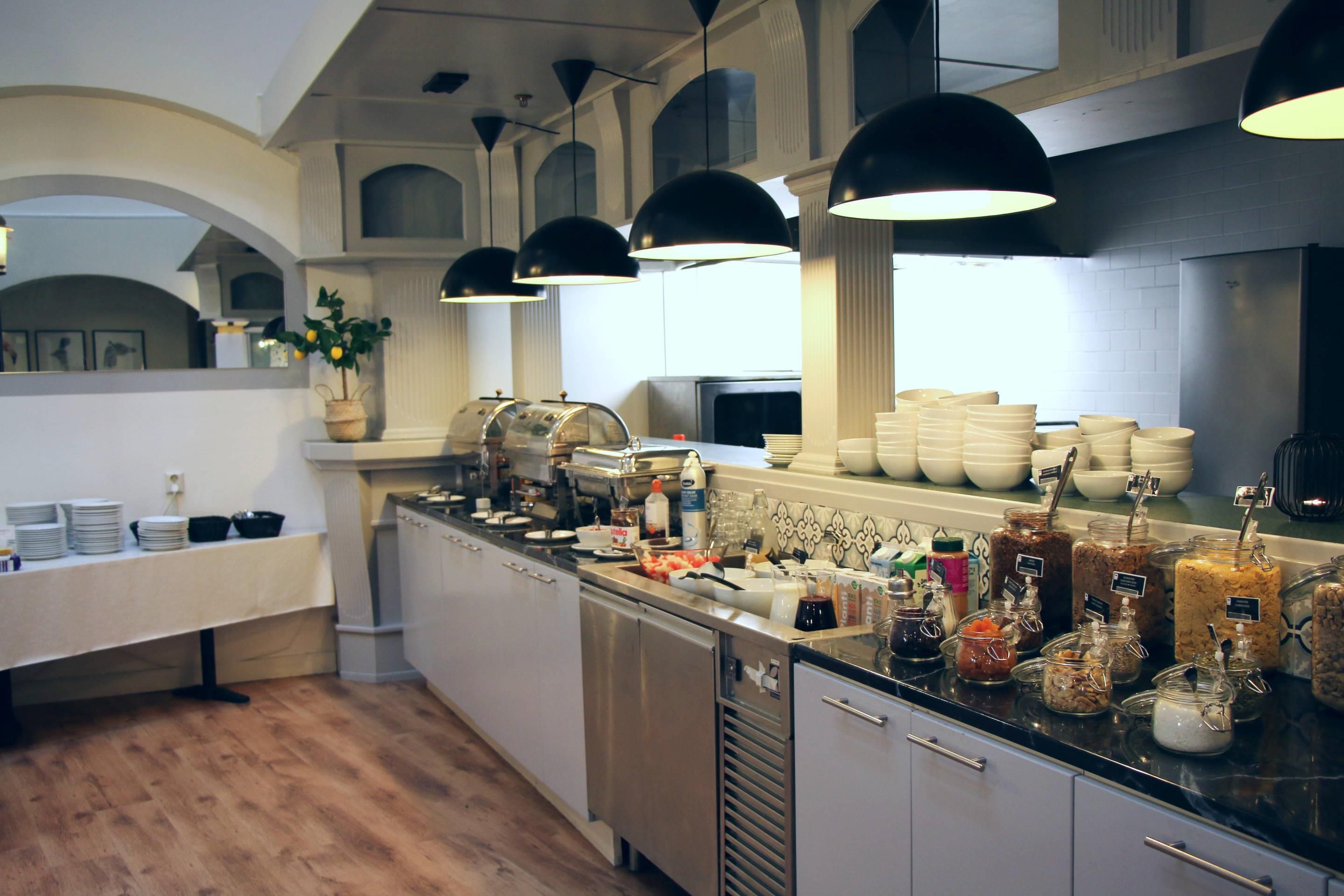 Una cocina moderna con una encimera amplia, diversos alimentos y una planta en maceta.