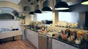Una cocina moderna con una encimera amplia, diversos alimentos y una planta en maceta.