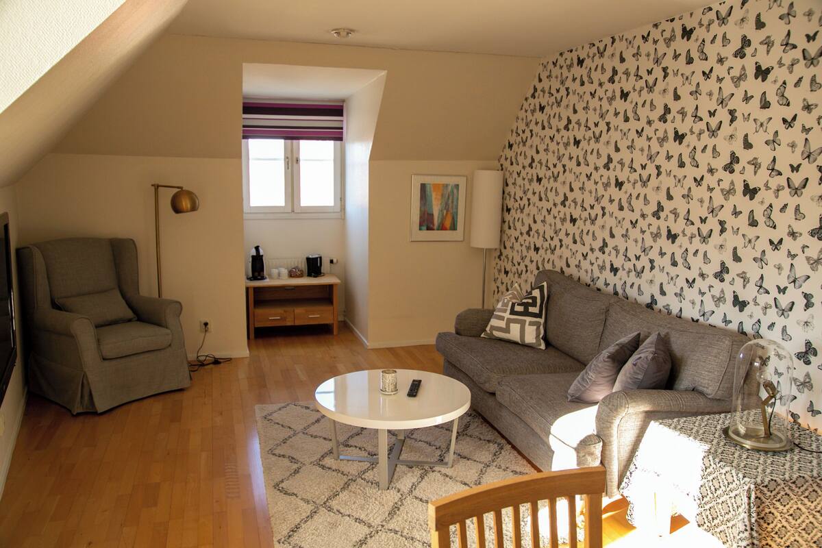 A living room with a sofa, armchair, and a round coffee table.