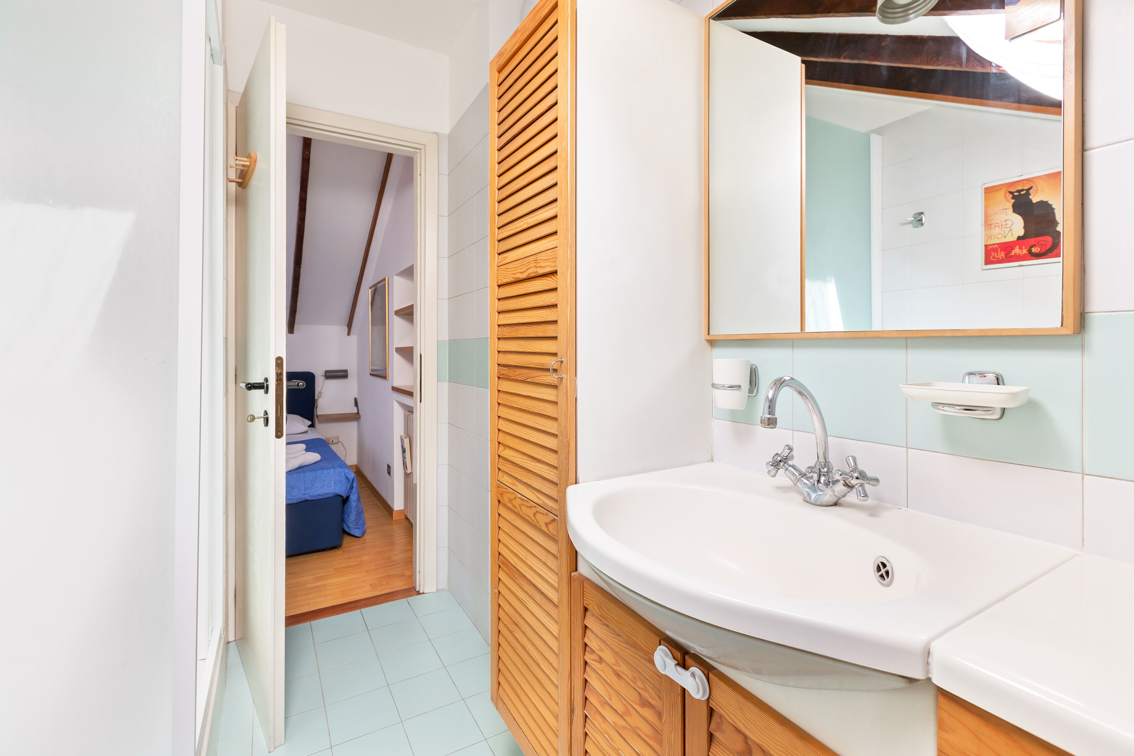 A bathroom with a wooden vanity, a sink, and a mirror.