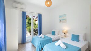 Habitación de hotel con dos camas, un balcón y un cuadro en la pared.