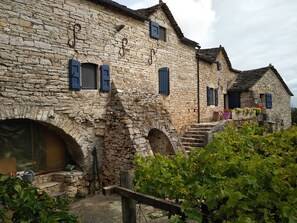 Un edificio de piedra con ventanas arqueadas y una escalera que conduce a un porche.