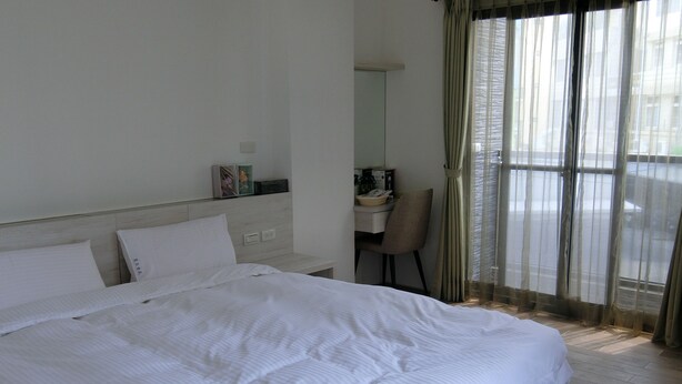 Une chambre d’hôtel avec un grand lit, un bureau et une chaise.