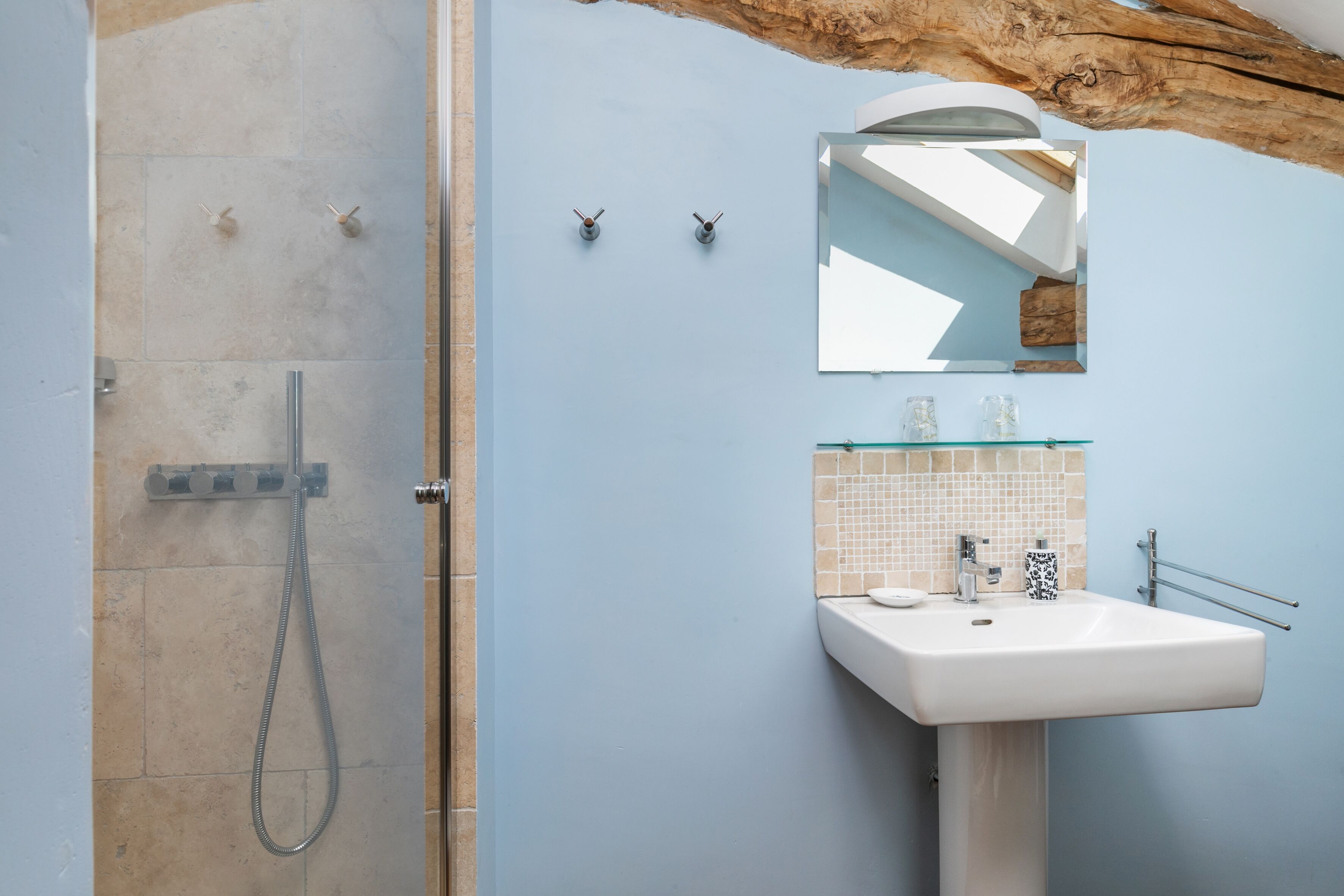 Un baño con ducha, lavabo y espejo.