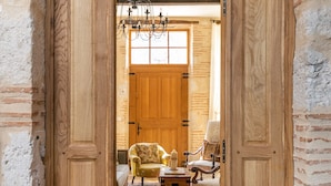 A wooden door leading to a room with two armchairs, a small table, and a patterned rug. - Domaine de Rambeau (Castelmoron-sur-Lot)