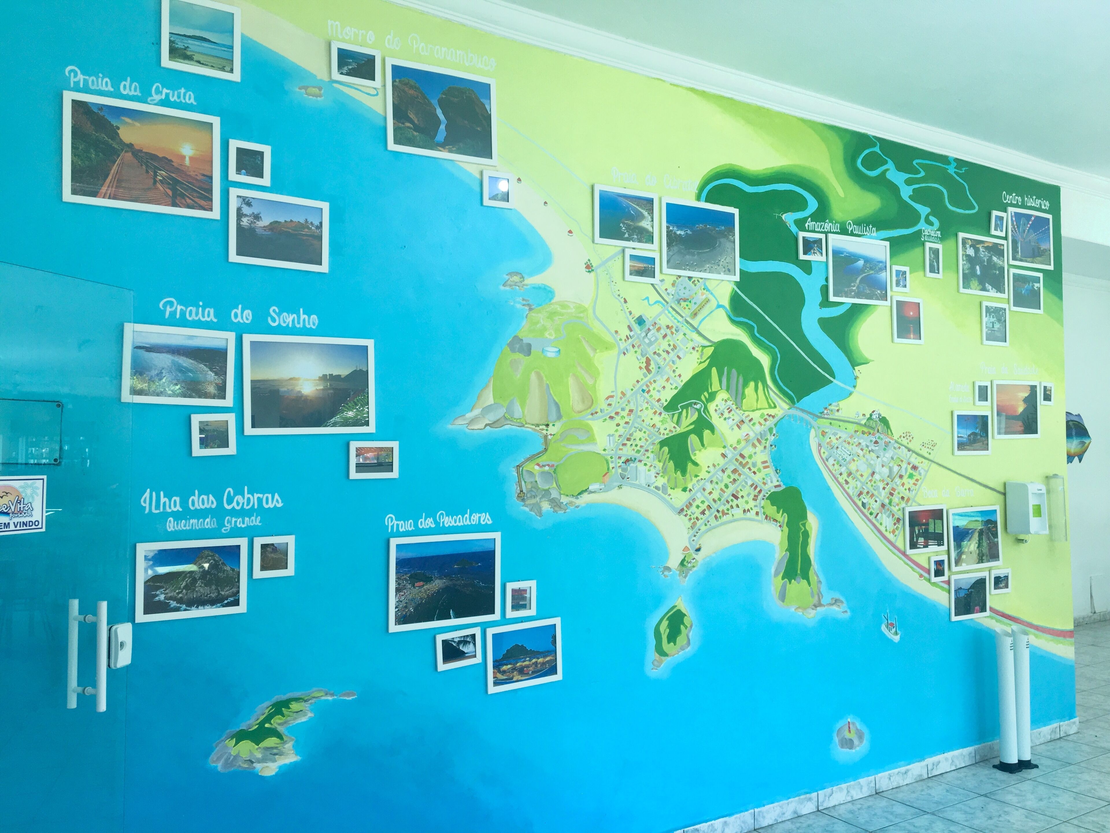 Una pared con un mapa y fotografías de diferentes lugares.