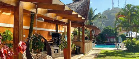 Un resort con piscina, mobiliario exterior y palmeras.