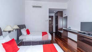 Una habitación de hotel con cama, lámparas de noche, televisión, escritorio y espejo.