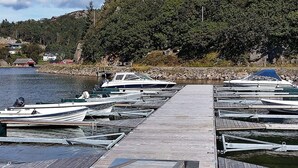 A wooden dock with boats moored on both sides. - 4 Person Holiday Home in Lyngdal (Lyngdal)
