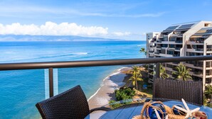 Ein Balkon mit Blick auf das Meer und einen Strand, ausgestattet mit einem Korbstuhl und einem Tisch mit einer Meerstern-Dekoration.