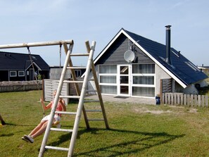 Un quartier résidentiel avec une maison dotée d’un toit en pente, d’une antenne parabolique et d’une cheminée.
