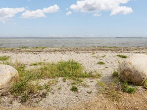 A coastal landscape with a rocky shoreline, sparse vegetation, and a clear view of the sea. - 6 Person Holiday Home in Bjert-by Traum (Bjert)