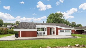 A single-story house with a tiled roof, a garage, and a patio area. - 6 Person Holiday Home in Bjert-by Traum (Bjert)