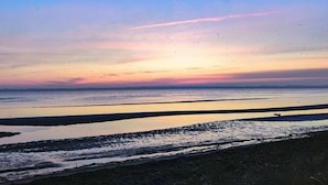 En strand med roligt vand og en klar himmel.