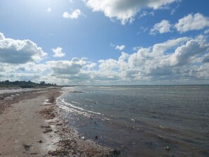 A beach with a wide sandy shore and calm water.