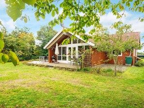 A house with a patio, a barbecue grill, and a garden.