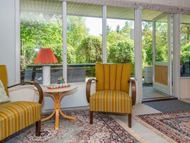A room with a large window, two chairs, a small table, and a rug.