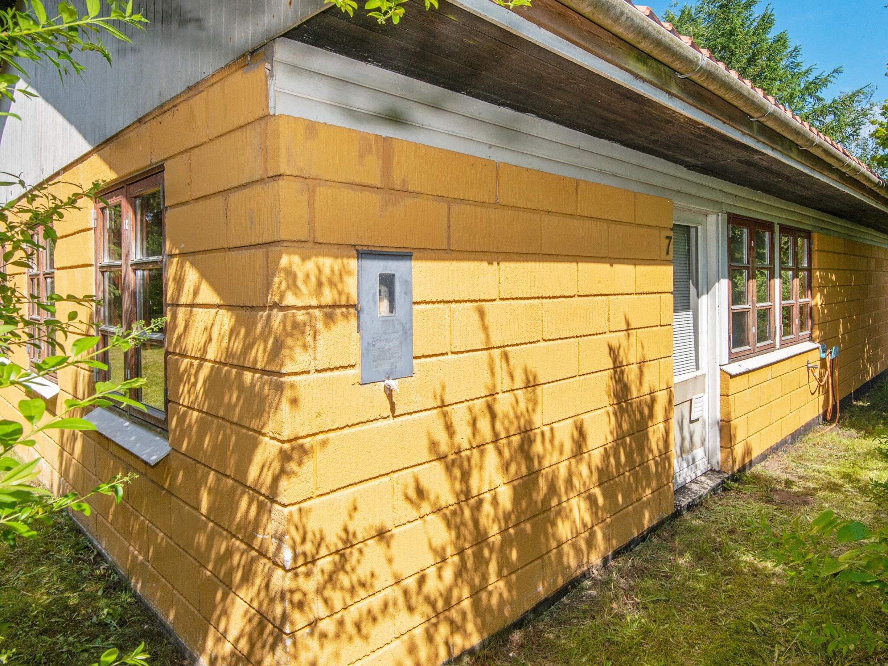 Una casa de ladrillo amarillo con una ventana pequeña y una puerta.