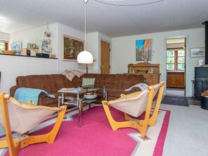 Relax in this inviting living room with a sofa, armchairs, and a large painting.