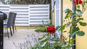 A patio with a white fence, a table, and chairs. - 6 Person Holiday Home in Hals (Hals)