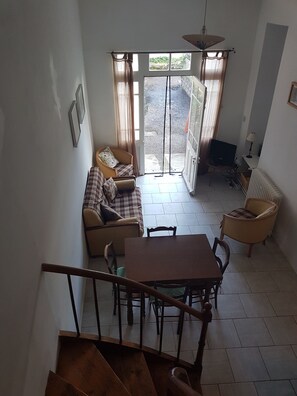 Un comedor con mesa y sillas, un sofá y una televisión.
