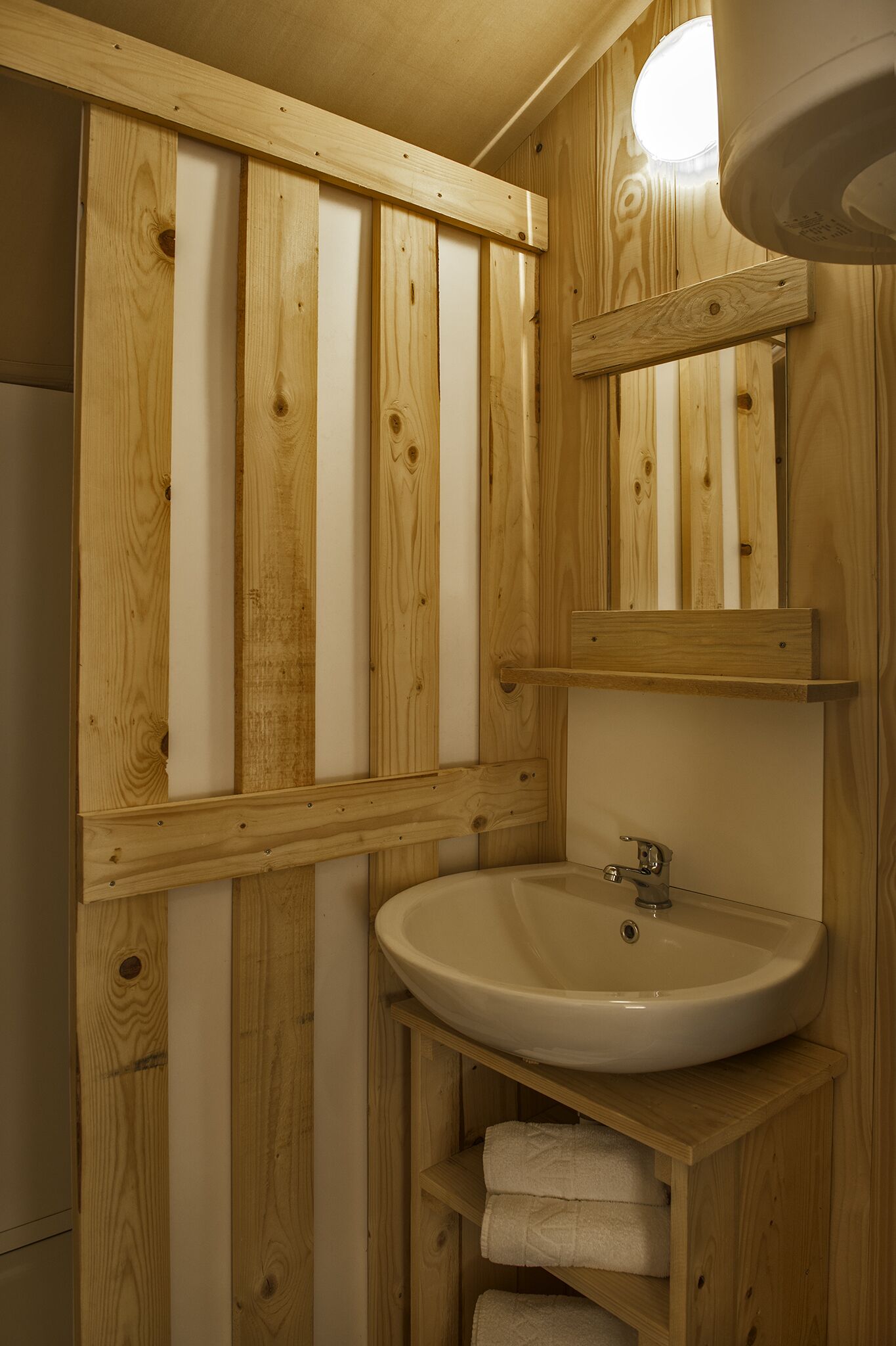 A wooden bathroom with a sink, shelves, and a mirror.