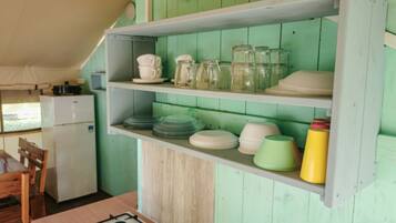 A kitchen with a gas stove, wooden cabinets, and a refrigerator.