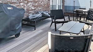 A patio with outdoor furniture, a barbecue grill, and a brick wall. - 5 Star Holiday Home in Ringkobing (Ringkobing)