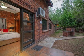 A brick building with a large window and an air conditioning unit mounted on the exterior wall. - Doringpoort Safari Lodge (Nkomazi)