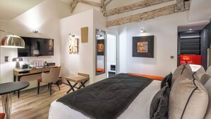 Une chambre d’hôtel moderne avec un grand lit, un bureau équipé d’un ordinateur, une chaise et un téléviseur.