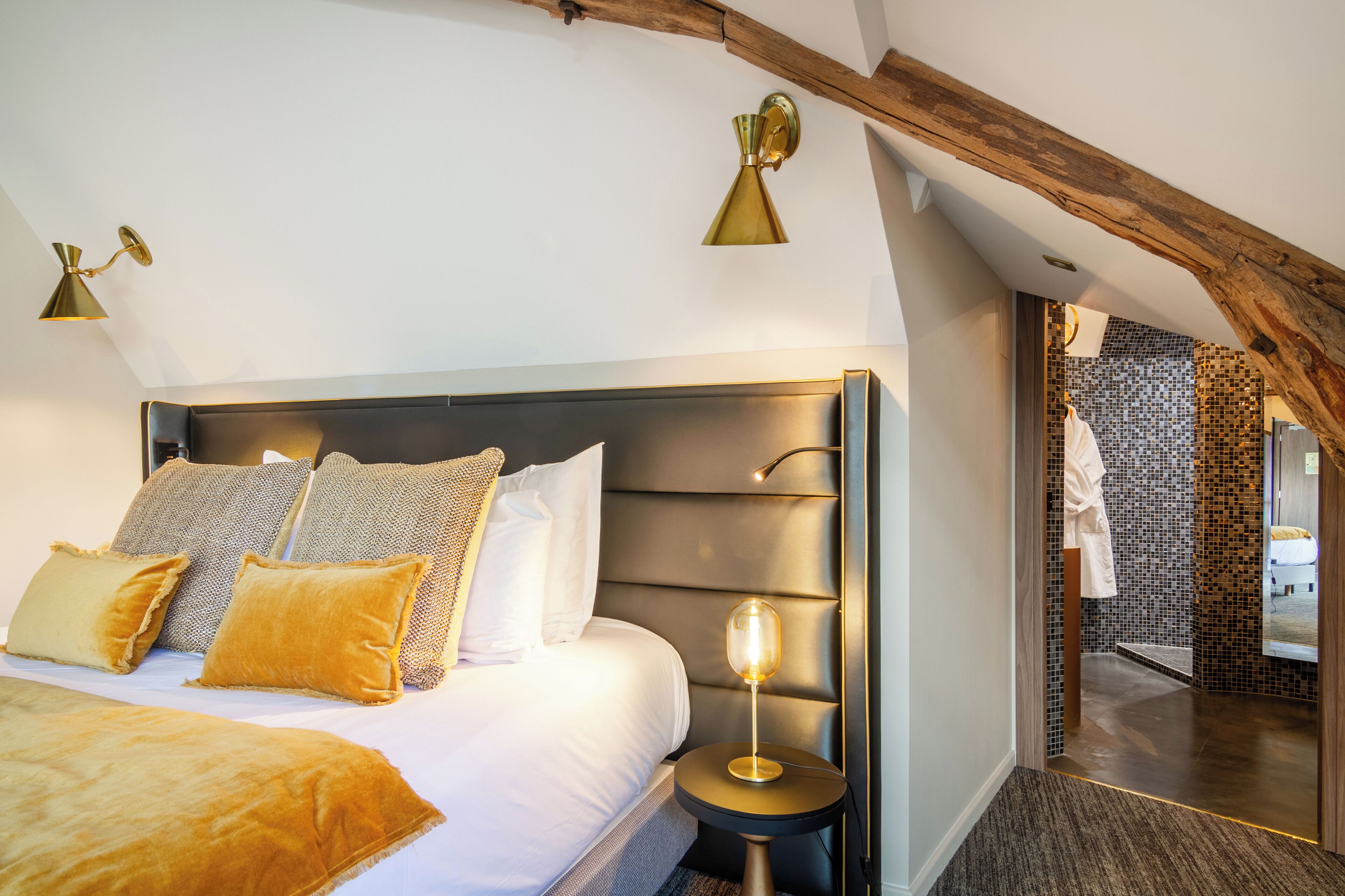 Un dormitorio con una cama grande, una mesita de noche y una lámpara de pared.
