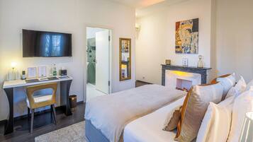 A modern hotel room with a bed, desk, and TV.
