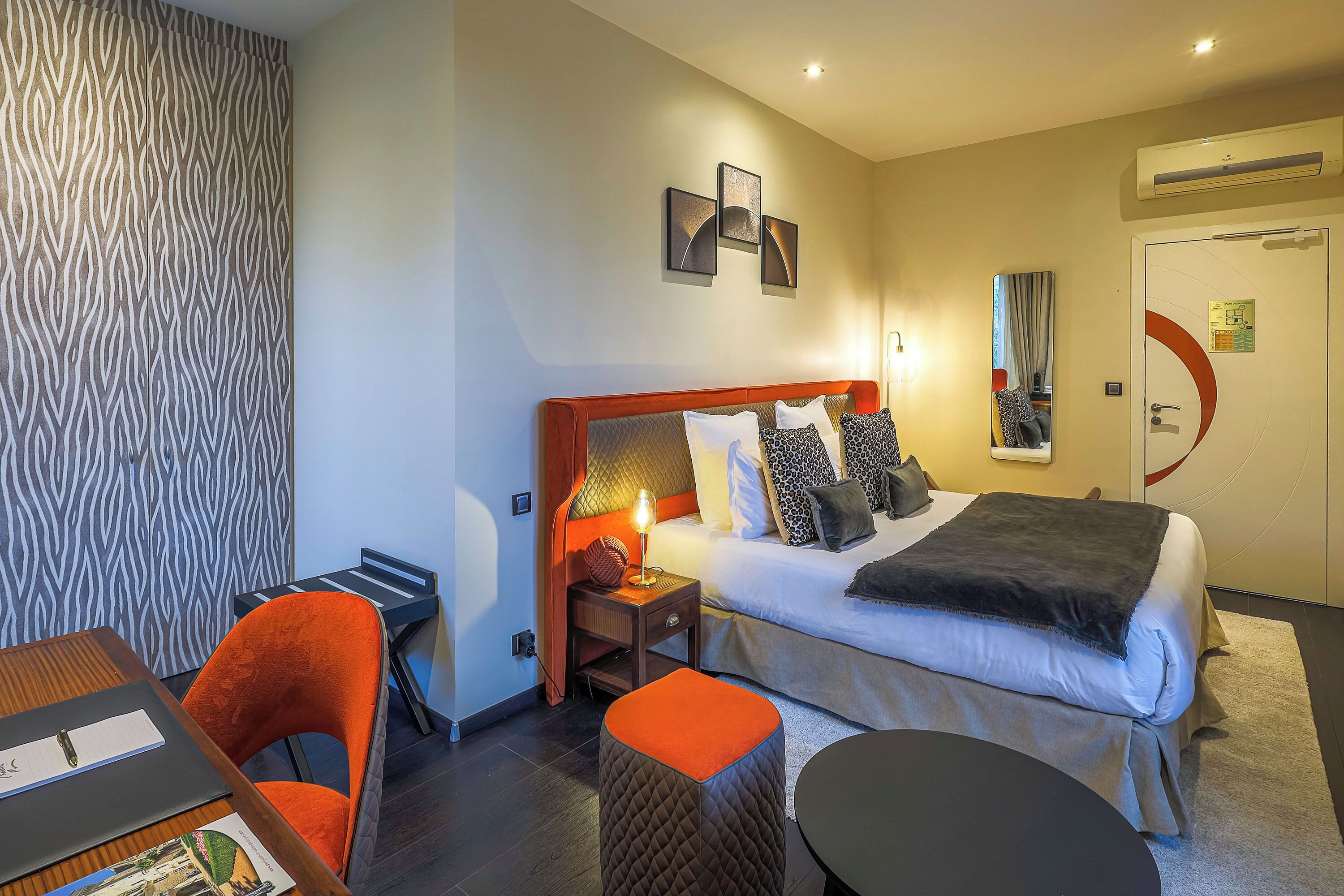Een hotelkamer met een bed, nachtkastje, tafel en stoel.