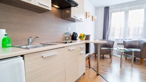 Une cuisine moderne équipée d’un évier, d’un plan de travail et d’une table en verre avec des chaises.