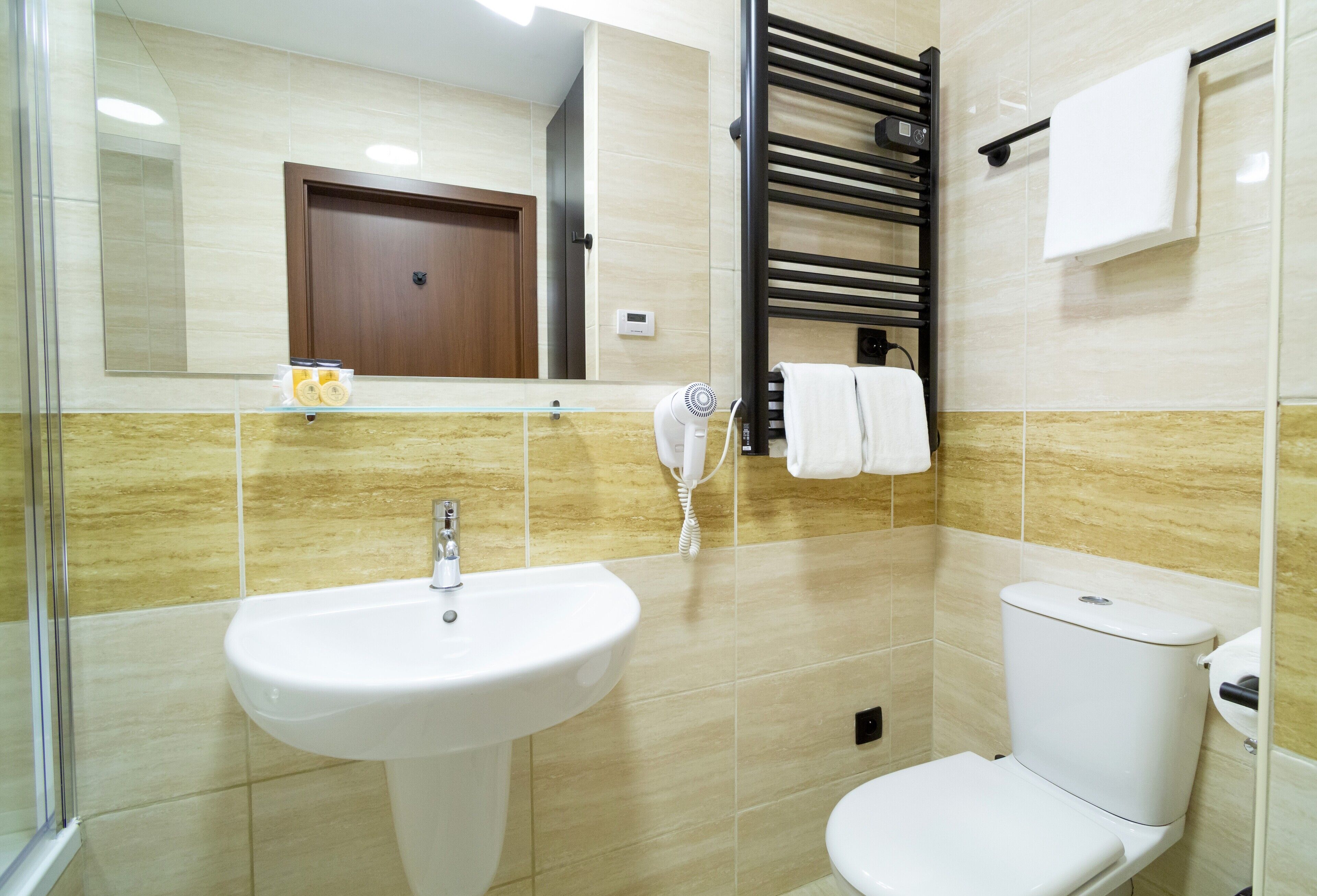 A bathroom with a sink, toilet, towel rack, and a mirror.