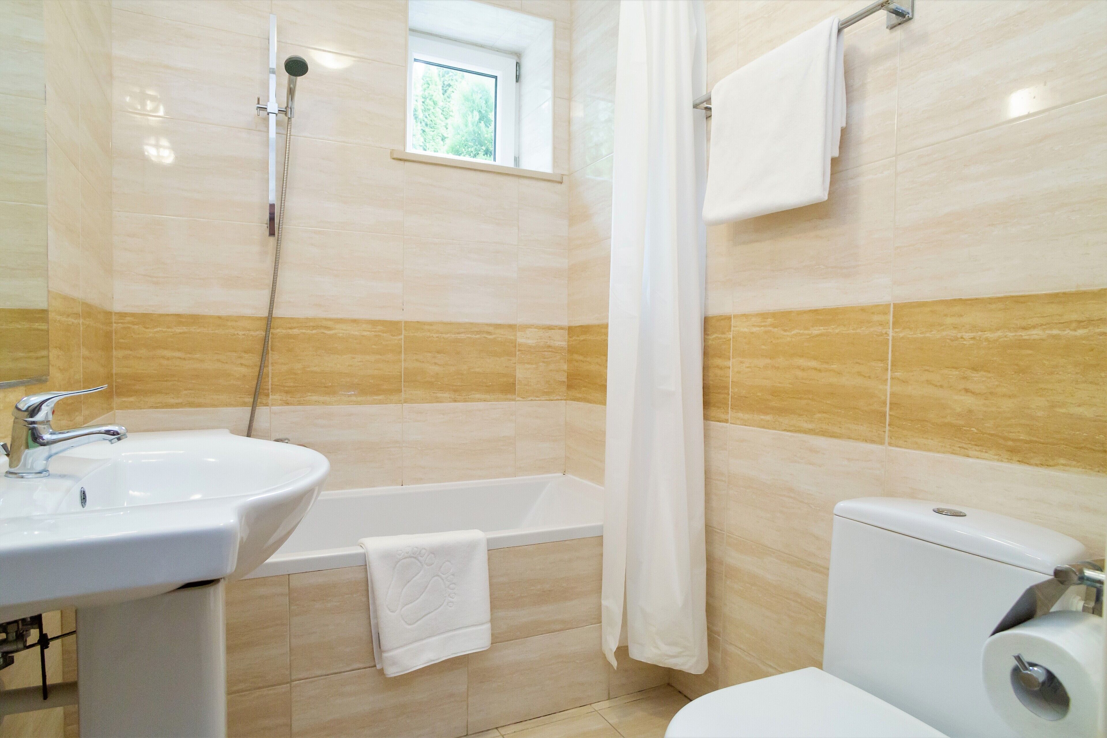 Un baño con lavamanos, bañera y inodoro.