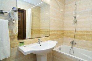 Eenvoudige driepersoonskamer, kitchenette | Badkamer | Een bad/douchecombinatie, een haardroger, handdoeken, zeep