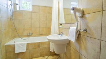 Un baño con bañera, lavamanos, secador de pelo y ducha.