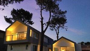 A modern two-story house with large windows and a tree in the front yard. - Best Villa in José Ignacio - Pinar del Faro - Brand New House (Departamento de Maldonado)