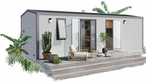 A modern single-story house with a patio, a chair, a table, and a potted plant. - Camping de Pujol (Argelès-sur-Mer)