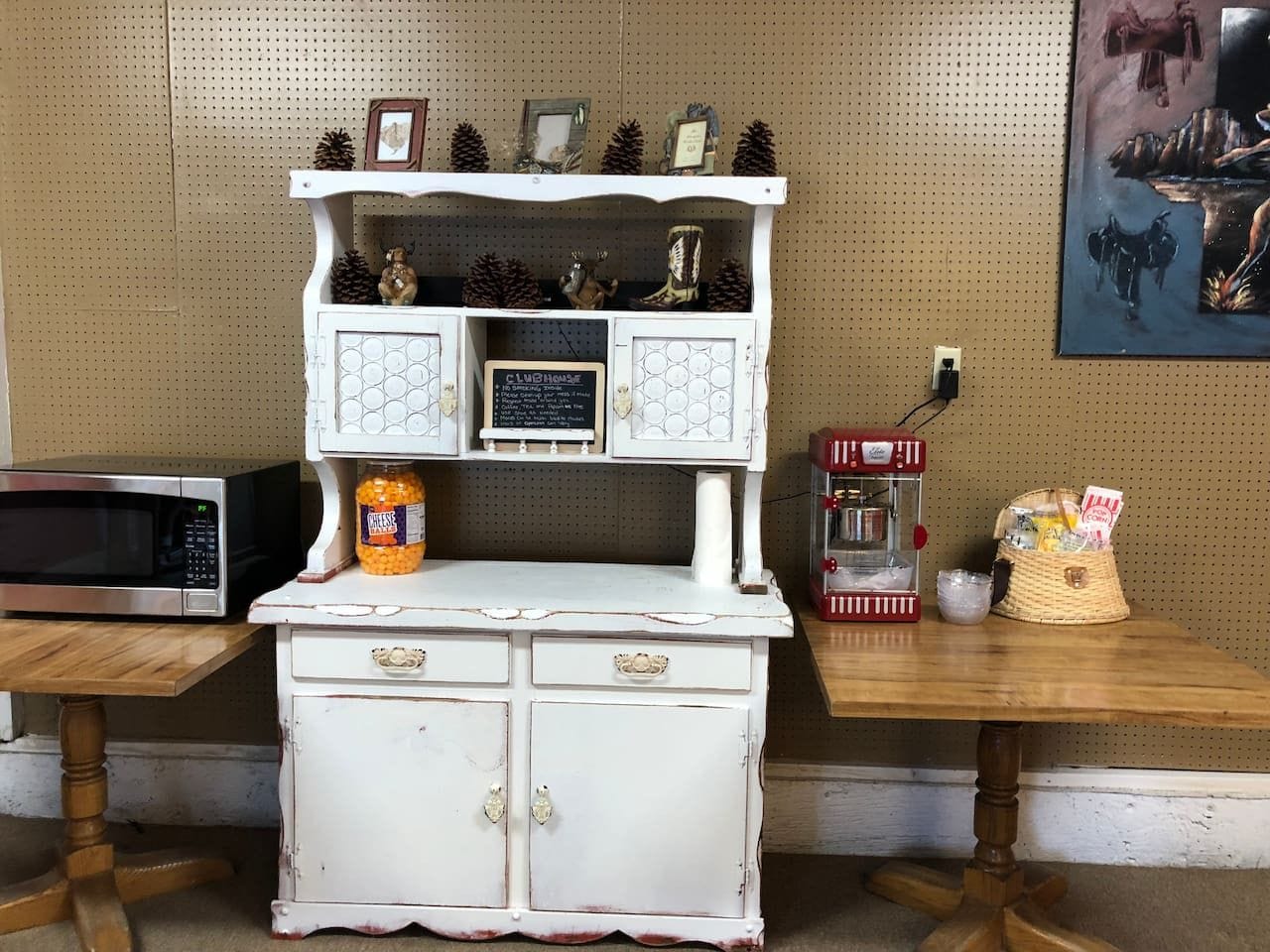 En vit köksbänk i vintage-stil med en mikrovågsugn, en burk med ostbollar och en röd kaffemaskin.