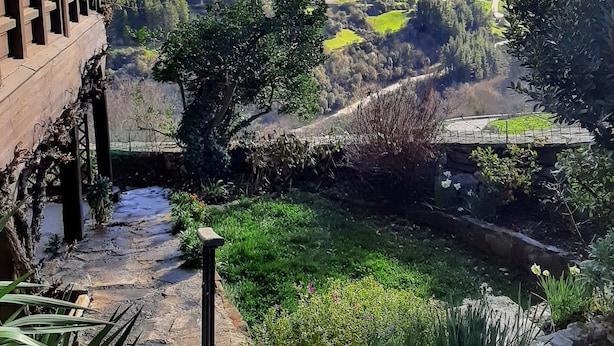 A garden with a stone pathway leading to a wooden deck overlooking a valley with green fields and distant mountains. - Richard and Suzanne Aparment cozy with an incredible views, quiet Valley. (Pico de Europa Cantabri)